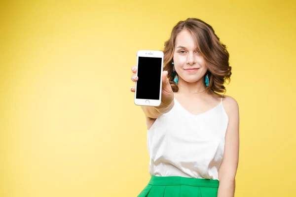 Girl showing mobile to the camera with shocked expression. — Stock Photo, Image
