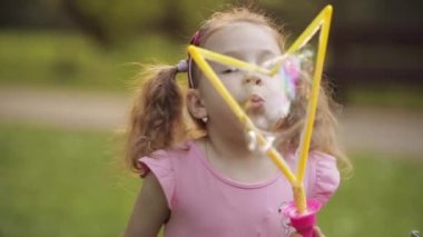 Kendinden emin oyuncu küçük sevimli kız büyük hava sabun kabarcık üfleyici orta yakın çekim üfleme