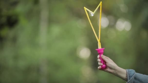 Weibliche Hand mit blitzend schimmernder Seifenblase in Nahaufnahme Zeitlupe — Stockvideo