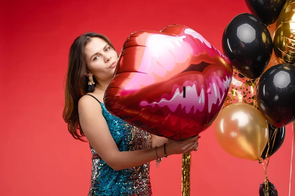 Sexy elegante Brünette in wunderschönem funkelnden Kleid mit Luftballons. — Stockfoto