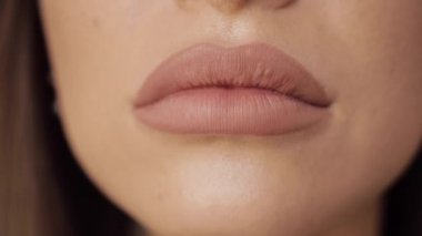 Extreme yakın çekim tombul kadın seksi dudaklar giyen çıplak ruj yapma öpücük ve gülümsüyor
