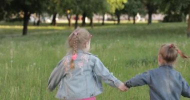 Hava kabarcık üfleyici ile çevrili bahçede yeşil çim üzerinde çalışan elleri ile tutarak üç küçük kız