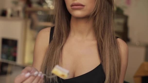 Beautiful sexy young woman enjoying eating appetizing pastry cake using fork tilt up — Stock Video