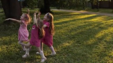 Büyük hava sabun kabarcık üfleyici yakalamak çalışırken oynayan mutlu küçük çocuk kız Grubu