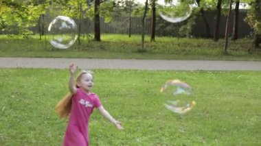 Büyük hava sabun kabarcık üfleyici yakalamak çalışırken oynayan mutlu küçük çocuk kız Grubu