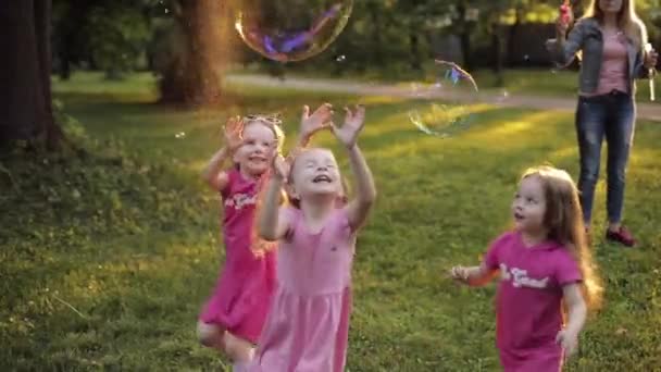 Gruppo di bambini felici bambina che gioca cercando di catturare grande soffiatore di bolla di sapone aria — Video Stock