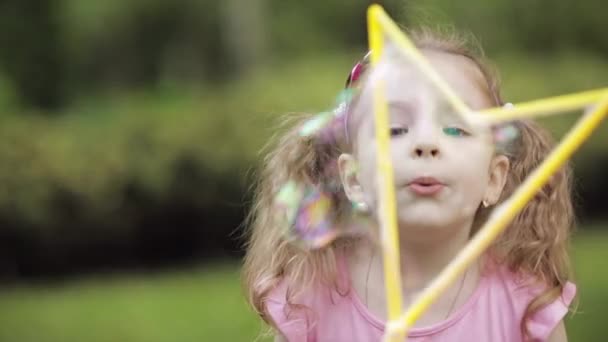 Zelfverzekerde speelse kleine schattige meid waait enorme lucht zeep Bubble blower medium close-up — Stockvideo