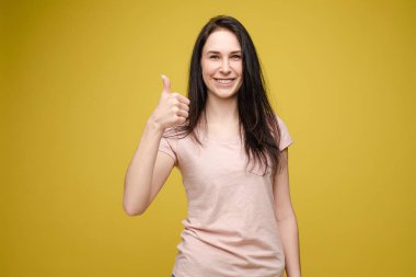 Beyaz gömlek ve kot başparmak gösteren Pozitif sarışın