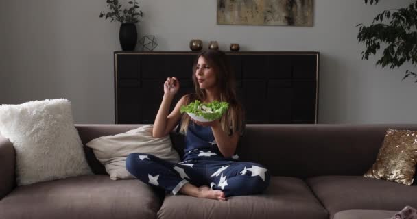 Retrato de hermosa mujer sonriente comiendo ensalada apetitosa haciendo aire beso tiro medio — Vídeos de Stock