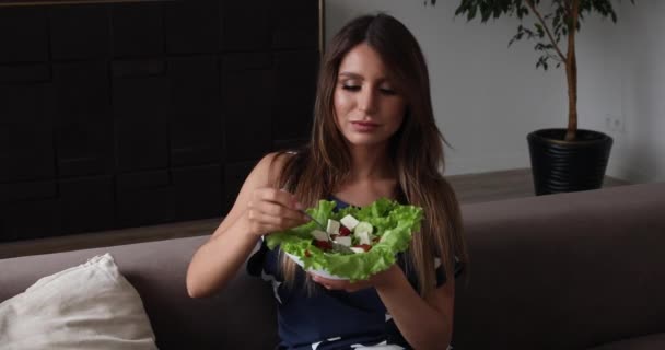 Retrato de hermosa mujer sonriente comiendo ensalada apetitosa haciendo aire beso tiro medio — Vídeos de Stock