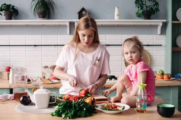 Anne onun küçük sevimli çocuk ile mutfakta akşam yemeği pişirme.