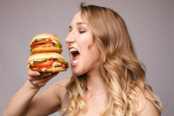 Жінка відкрила рот, щоб з'їсти гамбургер — стокове фото