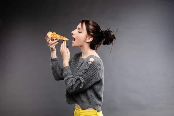 Jovem caucasiana com cauda comendo pedaço de pizza . — Fotografia de Stock