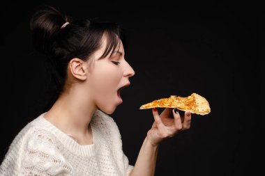 Aç genç kadının yakın yüzü açık ağız hazır pizza iştah açıcı parça ısırma