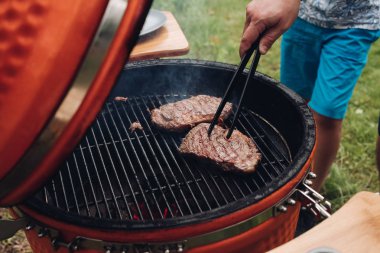 Barbekü yüksek açıda yakın çekim erkek el ızgara sulu parça et