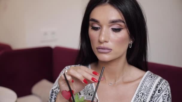 Крупным планом рот модной модели, пьющей свежий коктейль с помощью соломы, держащей стекло за руки — стоковое видео