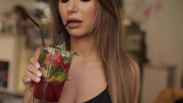 Közeli szája divat Női modell iszik friss koktél segítségével szalma tartó üveg kézzel — Stock videók
