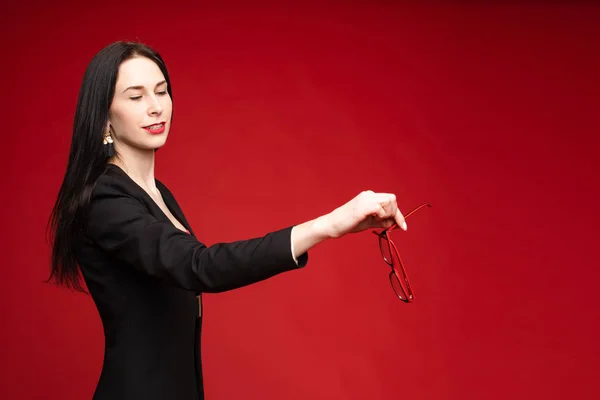 Model wirft ihre Brille weg. Isolation auf Rot. — Stockfoto