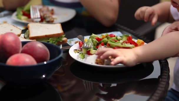 Criança irreconhecível almoçando na mesa . — Vídeo de Stock