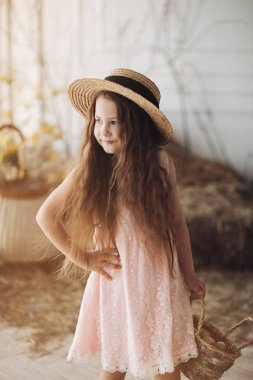 Şeftali elbise ve şapka kamera poz küçük güzel çocuk.