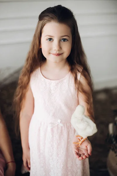 Flicka i klänning och hö hatt hålla korg med liten chick — Stockfoto