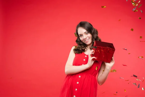 Glückliches Mädchen in rotem Kleid blickt in die Kamera — Stockfoto
