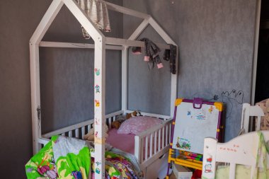 Gün ışığında dağınık çocuklar odası. Gün ışığında çocuğun odasında dağınık bir şekilde manzara. Çocuklar odada oynadı ve tam bir karmaşa bıraktı. Oyuncaklar yere dağılmış..