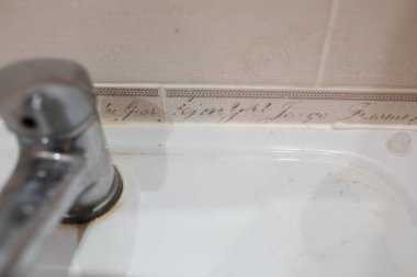 Kirli paslanmaz banyo musluğu. Banyo musluğu ve seramik lavabo.