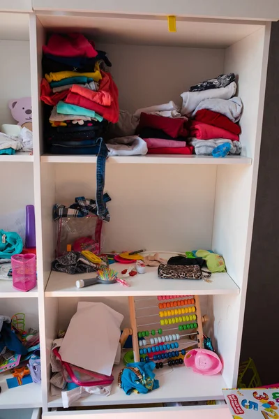 Messy kids room in daylight.View over messy in the kid s room in daylight. Children played in the room and left a total mess. Toys are scattered all around on the floor.