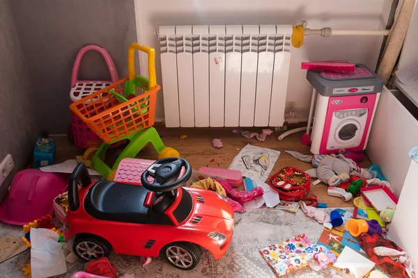 Messy kids room in daylight.View over messy in the kid s room in daylight. Children played in the room and left a total mess. Toys are scattered all around on the floor. — Stock Photo, Image