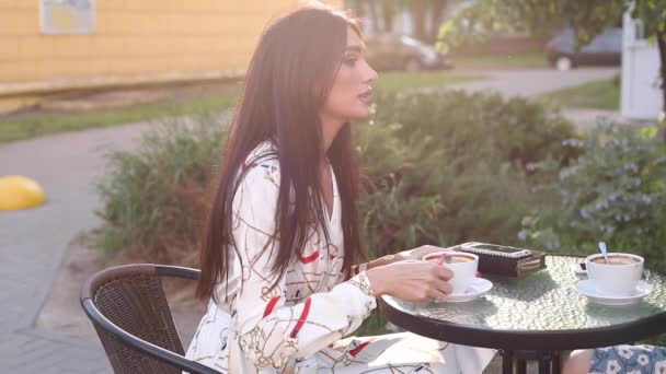 Dos amigas en vestidos elegantes escalofriantes en la terraza — Vídeos de Stock