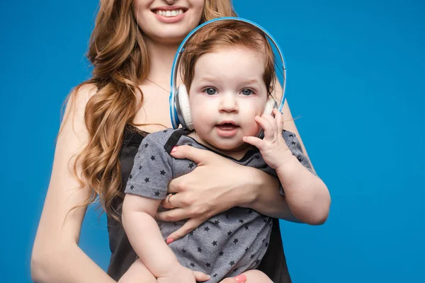 Mujer feliz con bebé niño en auriculares . — Foto de Stock