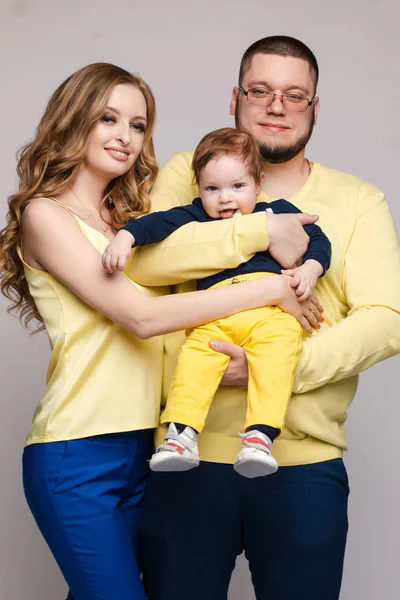 Familj i gul outfit poserar på isolerad bakgrund — Stockfoto