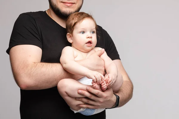 Padre manteniendo al pequeño bebé en las manos y besando al niño — Foto de Stock