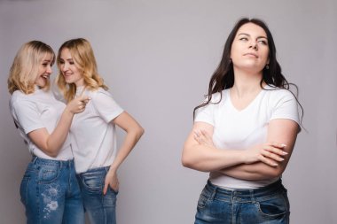 Rahatsız esmer ve iki sarışın arkasında dedikodu