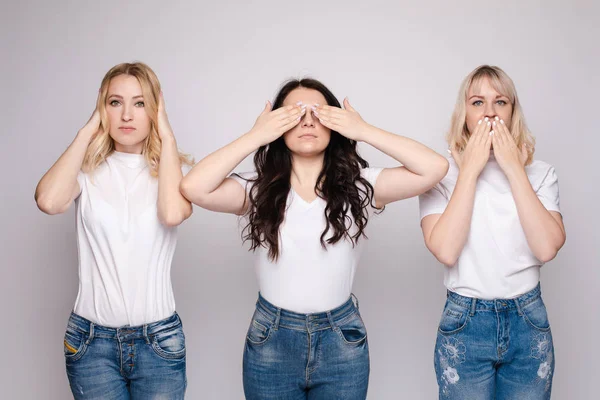 Троє молодих жінок ховають різні частини своїх облич . — стокове фото