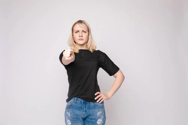 Confident young beautiful woman showing by hand stringent looking at camera posing isolated — Stock Photo, Image