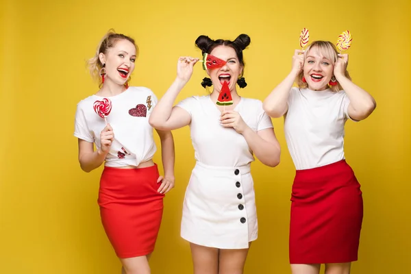 Grupo menina bonita amigo relaxar juntos posando com doce doce colorido no estúdio amarelo — Fotografia de Stock