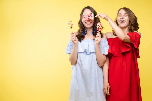 Horizontales Porträt zweier fröhlicher junger Frauen, die im Hintergrund zusammen Spaß haben — Stockfoto