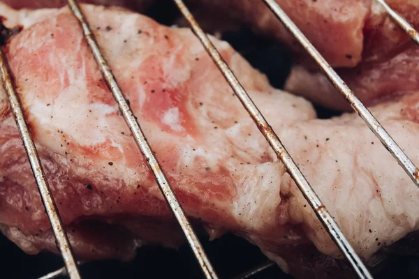 Ακραίο κοντινό-up μεγάλο κομμάτι νωπού κρέατος που καλύπτεται από άρωμα πικάντικο πιπέρι μαγείρεμα στο Γκριλ — Φωτογραφία Αρχείου