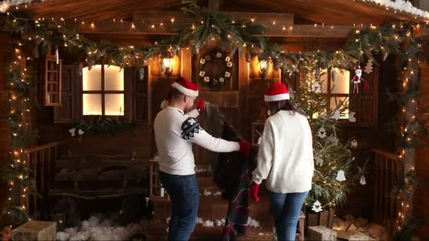 Karácsonyi romantika a szerelmesek. Guy a lány jött a faházba. — Stock videók