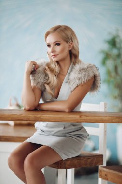 Bar tezgahında oturan gülümseyen moda güzel kadın
