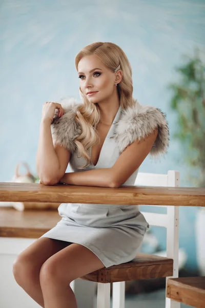 Bar tezgahında oturan gülümseyen moda güzel kadın — Stok fotoğraf