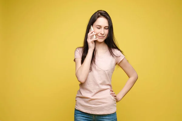 Snygg ung flicka i starkt ljus klänning pratar med telefon — Stockfoto