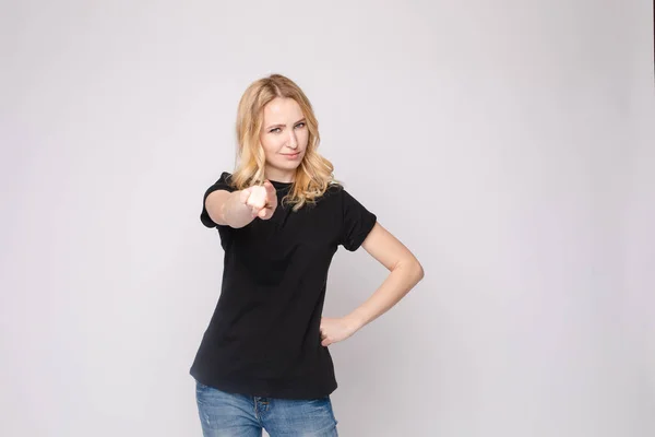 Confident young beautiful woman showing by hand stringent looking at camera posing isolated — Stock Photo, Image