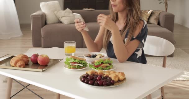 Женщина ест фрукты и десерты и пьет сок — стоковое видео