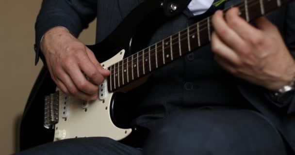 Hombre en traje oscuro sentado y tocando en la hermosa música jazz guitarra . — Vídeo de stock