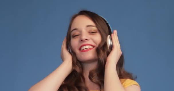 Menina em camisa amarela e fones de ouvido ouvindo música — Vídeo de Stock