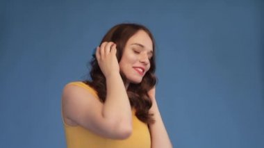 Neşeli genç kadın kulaklıkmüzik dinlerken dans.