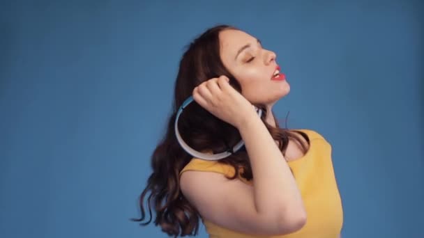 Η νεαρή γυναίκα χορεύει ακούγοντας μουσική στα ακουστικά. — Αρχείο Βίντεο
